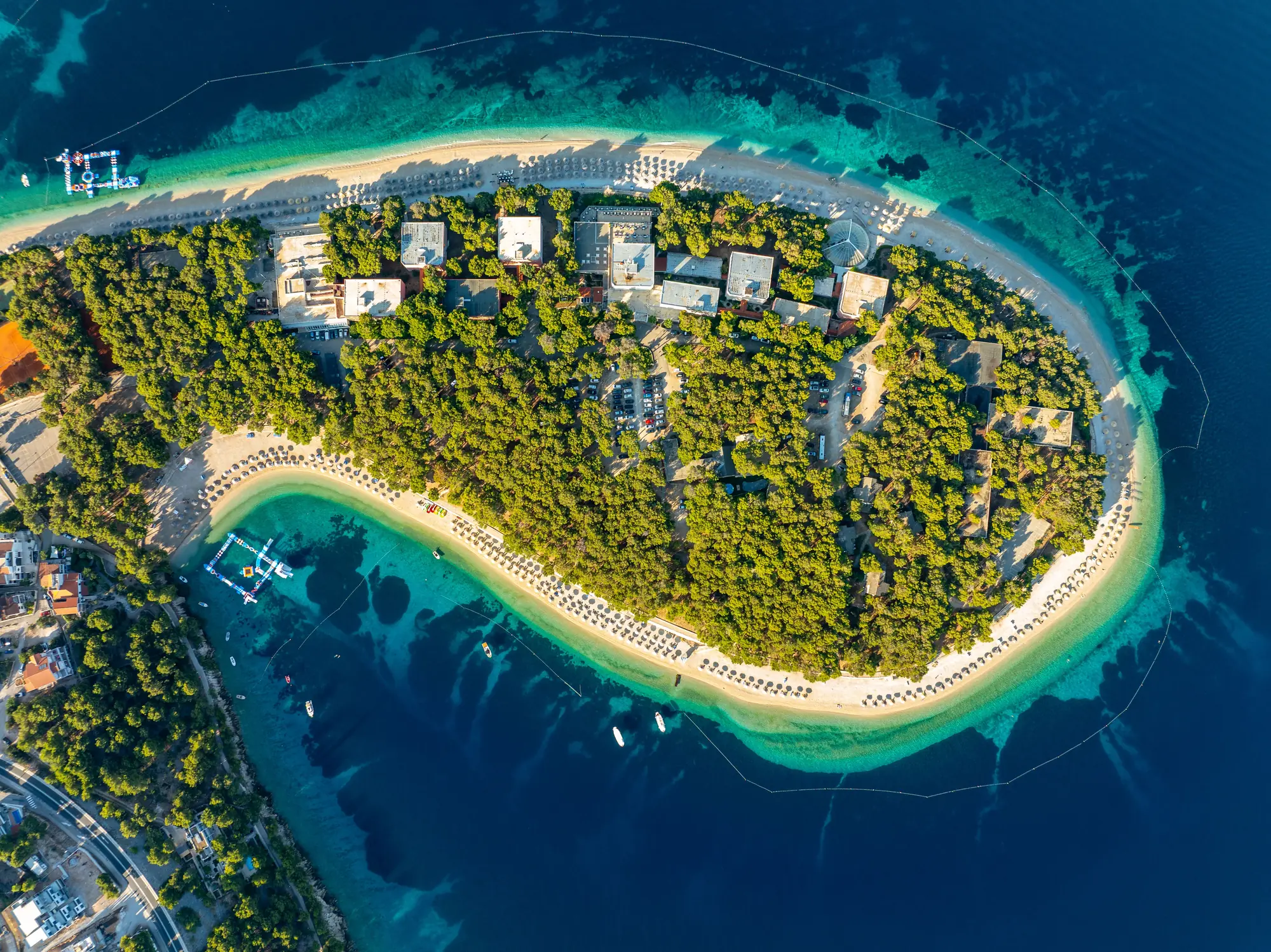 Aerial view of a wooded peninsula with beaches and turquoise water